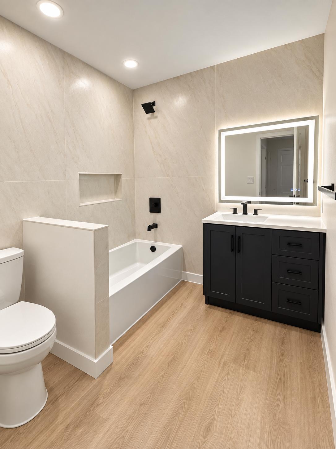 Bathroom with tiled tub surround, niche, half wall, and dark vanity