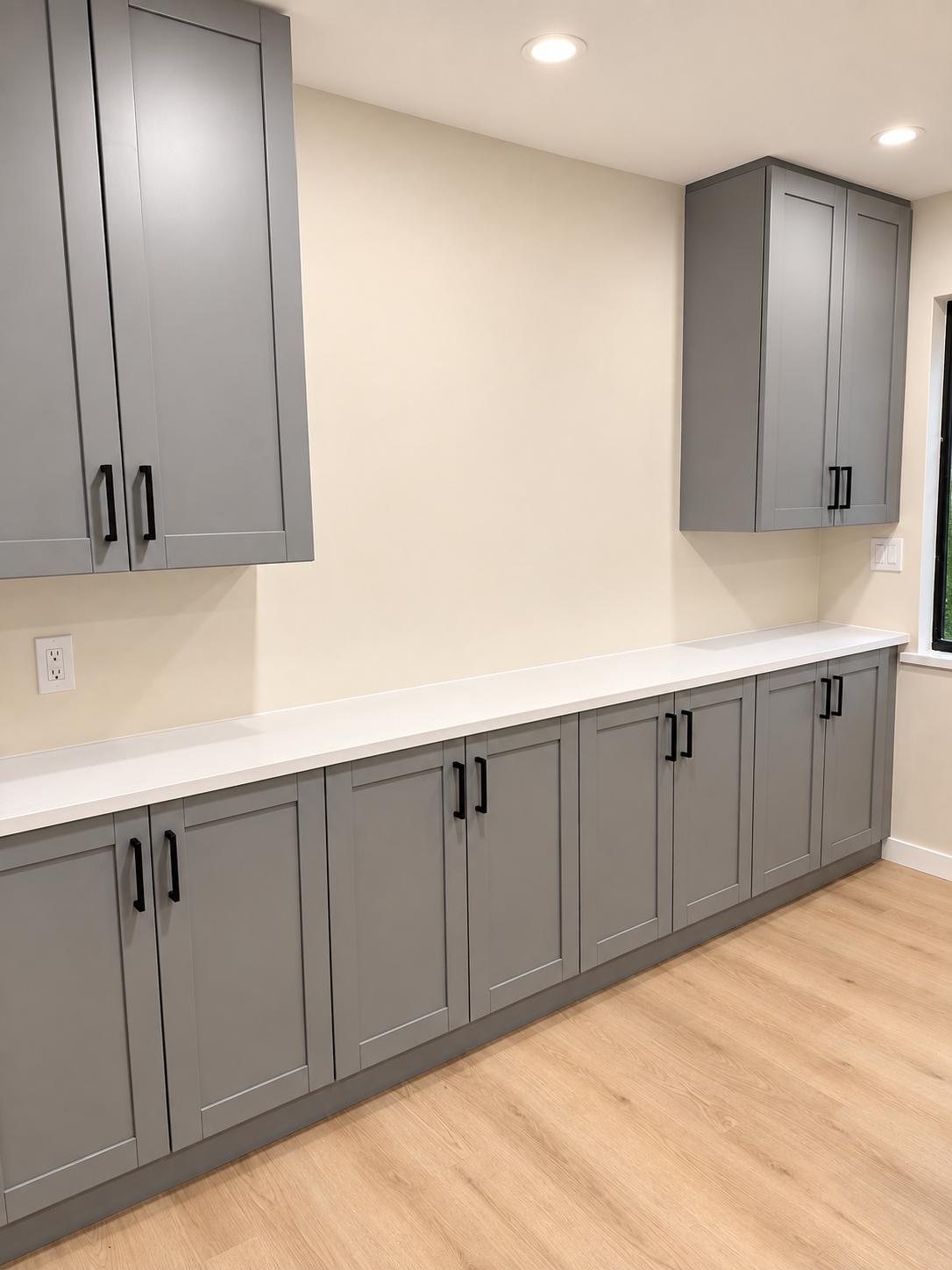 Long run of gray shaker cabinets with white countertop
