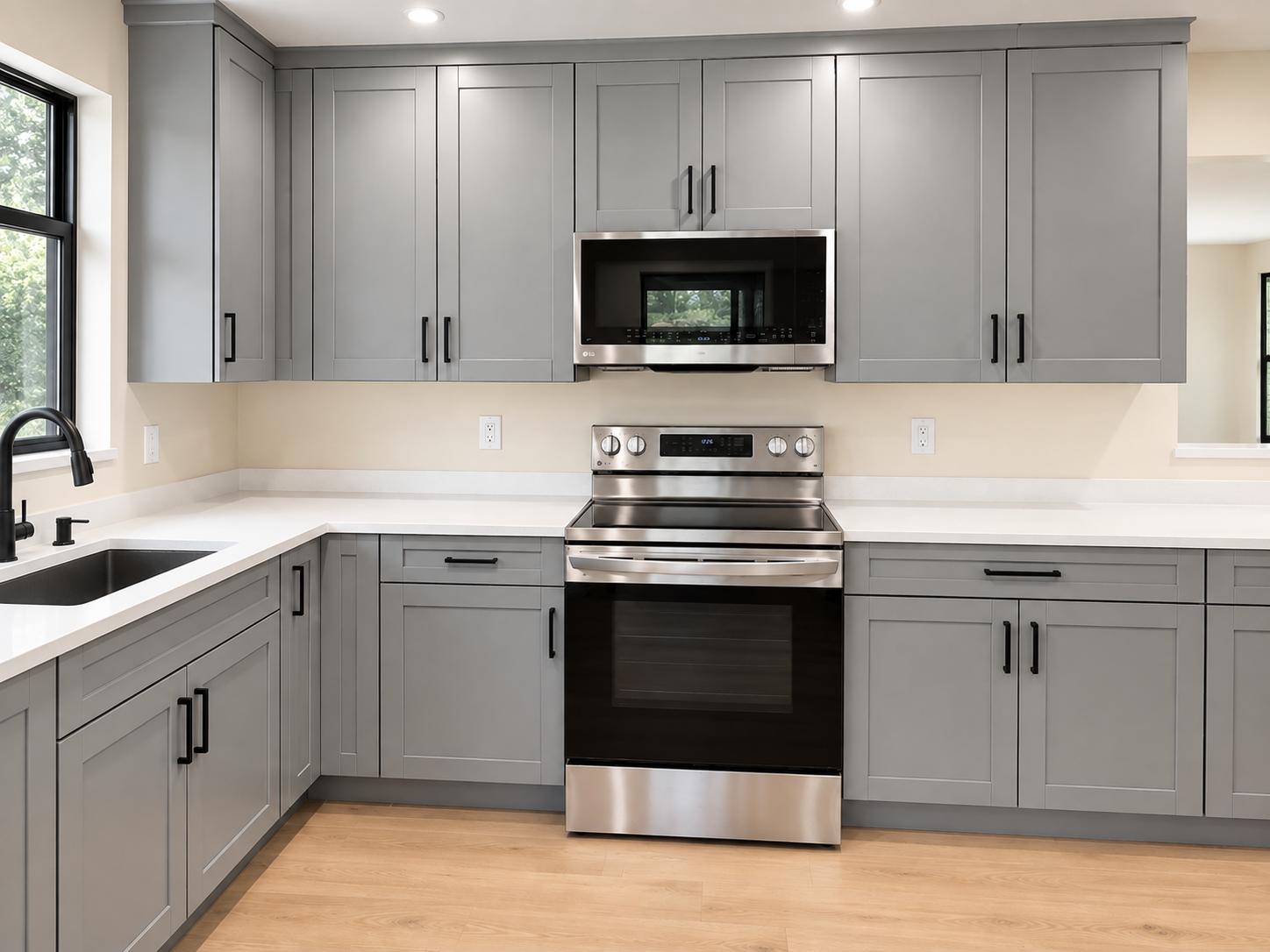 Kitchen with gray shaker cabinets, over-range microwave, and electric range